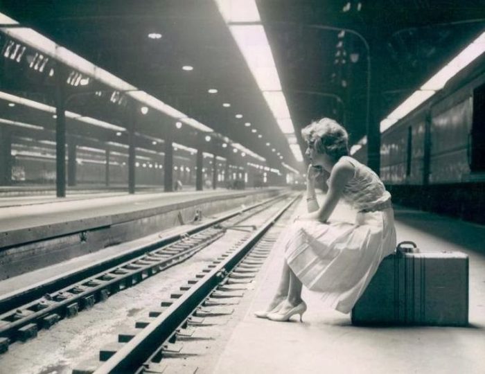 woman-sitting-on-suitcase-b-and-w-1960